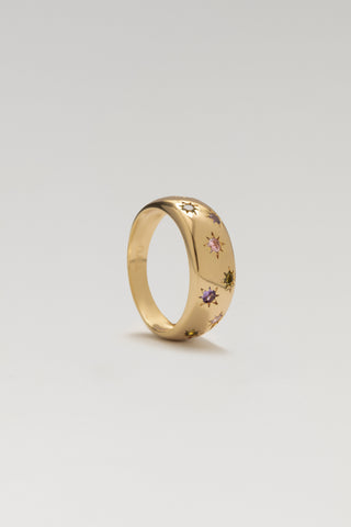 Jude ring, gold plated, standing at an angle showing the domed band and star-set pink, purple and green cubic zirconia