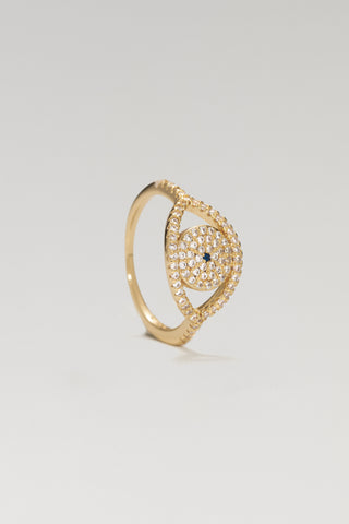 Protective Eye ring, gold plated, standing at an angle to show the pave eye outline and blue centre stone