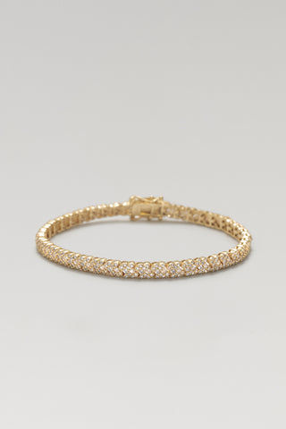 Roxy tennis bracelet, gold plated, lying flat with its box clasp and X-pattern cubic zirconia settings