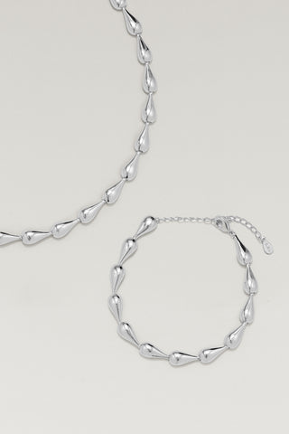 Riva necklace and Riva bracelet, silver-tone, laid together showing the hollow teardrop links