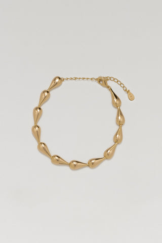 Riva bracelet, gold plated, lying in a circle with its extender chain and tag, hollow teardrop links