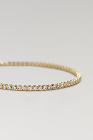Alma mini tennis bracelet, gold plated, angled close-up of the bezel-set cubic zirconia line
