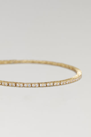 Clara mini tennis bracelet, gold plated, angled close-up of the claw-set round cubic zirconia