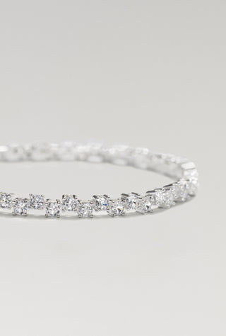 Ramona tennis bracelet, silver plated, angled view of the staggered stone rows on a pale surface