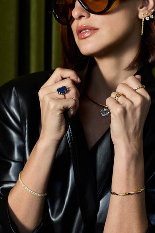 Model in a black leather jacket wearing the gold plated Roxy tennis bracelet, a twisted bangle and a collar necklace