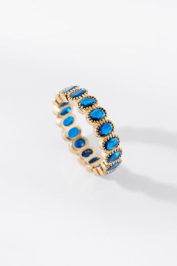 Aurora gold ring featuring oval blue gemstones on a white background
