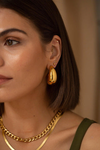 Close-up of Dot gold stud earrings showing a smooth polished dot finish