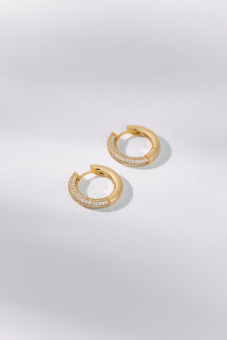 Eternity gold hoop earrings featuring delicate stone detailing on a white background