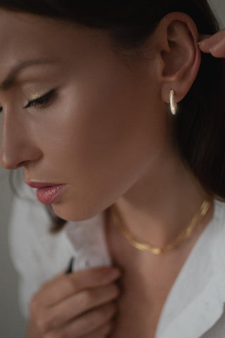 Eternity gold hoop earrings worn on the ear with subtle stone sparkle
