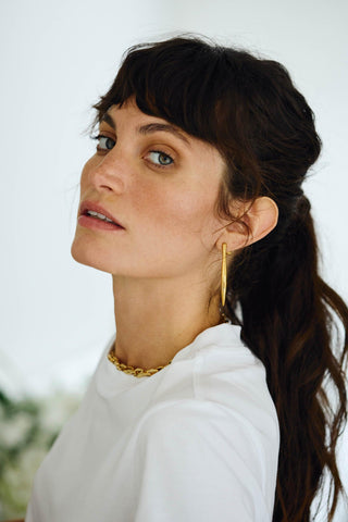 Noa gold sculptural earrings on white background