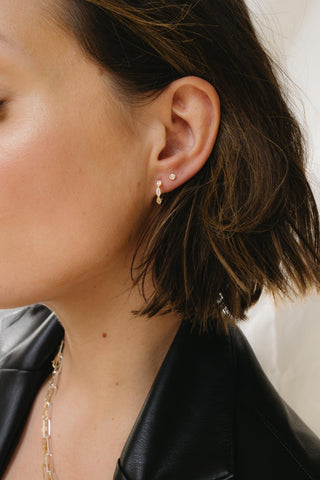 Close-up of Nova gold stud earrings showing polished starburst detailing