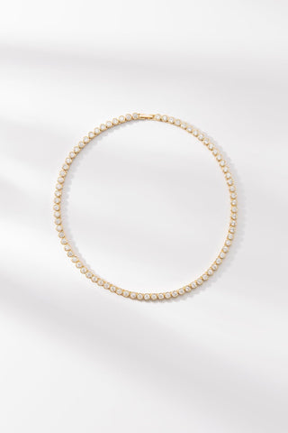 Round Tennis Necklace by One Dame Lane, classic gold tennis necklace set with round-cut stones.