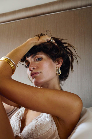 Close-up of Valentina Earrings, gold oval statement earrings with pavé crystal design.